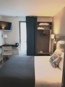 a hotel room with a bed and a desk at The Originals City, Hôtel Novella, Nantes Centre Gare in Nantes