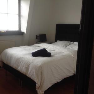a bedroom with a bed with a hat on it at Beemster Experience in Middenbeemster