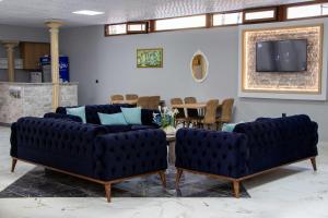 a living room with two blue couches and a table at Ersoy İkiz Otel in Antalya