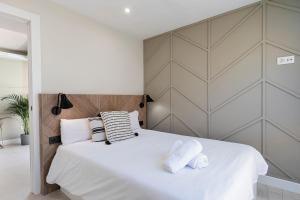 een slaapkamer met een groot wit bed en 2 handdoeken bij Malagaroom Victoria 43 in Málaga