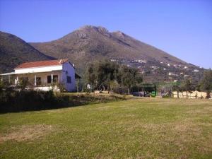 a house in a field with a mountain in the background at AZIENDA AGRICOLA 25 PONTI in Gaeta