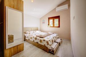 Schlafzimmer mit einem Bett und einem Spiegel in der Unterkunft Apartment Rhizon in Risan