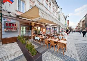 a restaurant with tables and chairs on a city street at Prague Inn in Prague