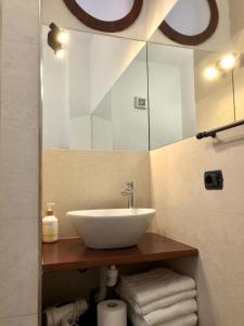 a bathroom with a sink and a mirror and towels at B&B Roomantic & Piscina Idromassaggio in Cefalù