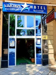 Ingresso socchiuso di un vecchio negozio con un cartello di Hotel Old Star a Batumi