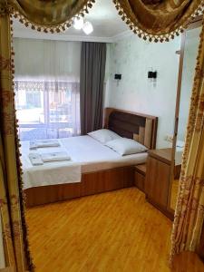 una camera con un grande letto e pavimenti in legno di Hotel Old Star a Batumi