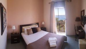a bedroom with a large bed and a window at Villa Pappas in Kanali +48 photos