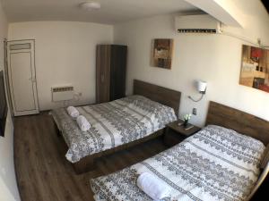 two beds in a hotel room with a mirror at Samuil Apartments in Burgas