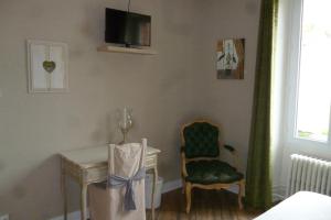 Habitación con mesa, silla y TV. en Le Relais de Montigny en Montigny-le-Gannelon