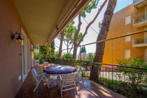 uma varanda com uma mesa, cadeiras e uma árvore em Elegante appartamento di 200 mq con vista a Sanremo em Sanremo