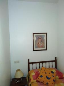 une chambre avec un lit et un tableau au mur dans l'établissement El Carmen, à Cazalla de la Sierra