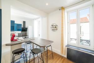 eine Küche mit einer Theke und Hockern in einem Zimmer in der Unterkunft Appartement Le Grand Dupont du Parc Ste-Marie - OscarNewHome in Nancy