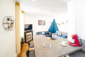 una sala de estar con una mesa y un sofá en Le Grand Dupont du Parc Ste-Marie - Logements Insolites, en Nancy