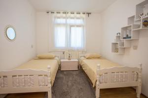 - une chambre avec 2 lits et une fenêtre dans l'établissement Apartment Rosse, à Poreč