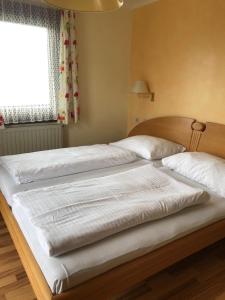 A bed or beds in a room at Hotel Garni Haus am Wald