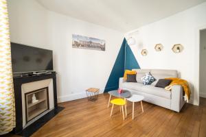 a living room with a white couch and a fireplace at Appartement Le P'tit Dupont - OscarNewHome in Nancy