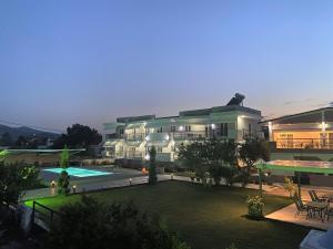 - un grand bâtiment avec une piscine en face dans l'établissement Littore Maris, à Nea Vrasna