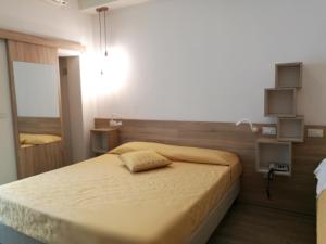 a small bedroom with a bed with a yellow bedspread at Hotel Marilinda in Cesenatico