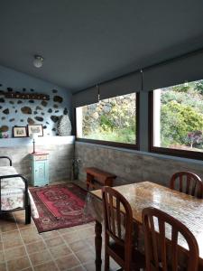 een eetkamer met een tafel en stoelen en 2 ramen bij Casa Anita in Tajace de Abajo