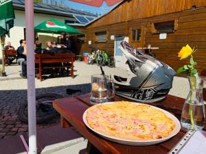 Penzion Praděd في مالا مورافكا: بيتزا جالسه على طاوله بجانب دراجه ناريه