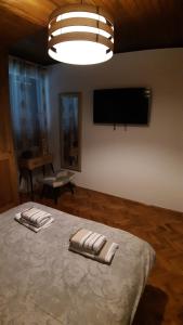 a bedroom with a bed with two towels on it at Holiday House Belajec in Popovača
