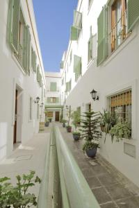 an empty alley with potted plants and buildings at Apartamentos Gravina in Tarifa
