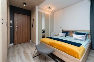een slaapkamer met een groot bed en een stoel bij Grey Horse Apartment premium in Gdańsk