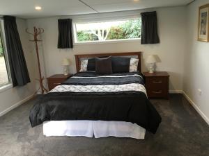 a bedroom with a large bed and a window at Fergus Hideaway in Te Anau