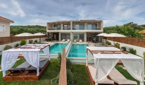 an exterior view of a house with a swimming pool at Sabbia D`oro Beach Villa in Méson Yerakaríon