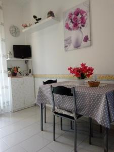 un comedor con una mesa y un jarrón de flores en Casa Sole Mare, en Riposto