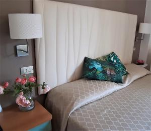 Schlafzimmer mit einem Bett mit einem Kissen und einem Tisch in der Unterkunft Hotel Eugenio in Rimini