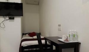 a small room with a table and a television at Max Ferringhi Hotel in Batu Ferringhi