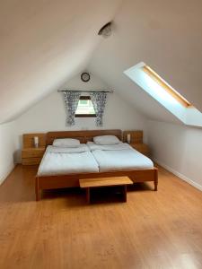 a bedroom with a bed in a attic with a window at Apartma Pr'Toman in Kamna Gorica