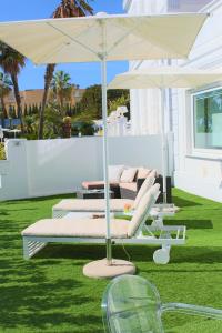 patio z 2 łóżkami i parasolem w obiekcie Sanremo Luxury Suites w San Remo