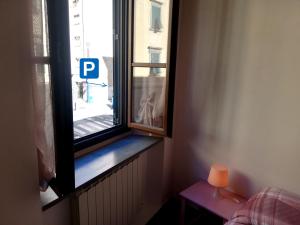 una ventana en una habitación con una mesa y una lámpara en La casa di Giosuè en Livorno