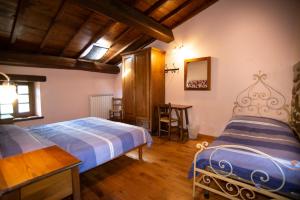 1 Schlafzimmer mit 2 Betten, einem Tisch und einem Stuhl in der Unterkunft Agriturismo Il Corniolo in Castiglione di Garfagnana + 66 Fotos