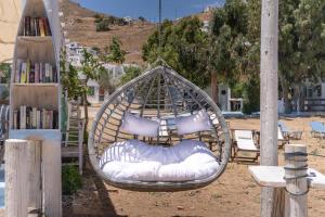 a hammock with pillows and a bed in a yard at Alexandros by the Beach - Serifos in Livadakia