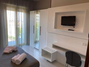 a living room with a tv on a wall at Hotel Biancamano in Rimini