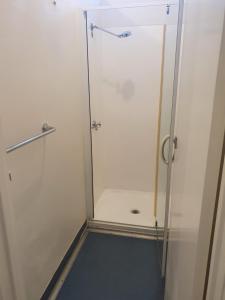y baño con ducha y puerta de cristal. en College Lawn Hotel, en Melbourne
