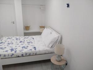 1 dormitorio con 1 cama con edredón azul y blanco en Apartamentos Areia e Mar Sul en Vila Praia de Âncora