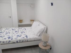 ein Schlafzimmer mit einem Bett mit einer blau-weißen Bettdecke in der Unterkunft Apartamentos Areia e Mar Sul in Vila Praia de Âncora
