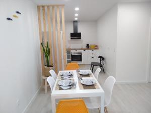 a white table and chairs in a white kitchen at Apartamentos Areia e Mar Sul in Vila Praia de Âncora