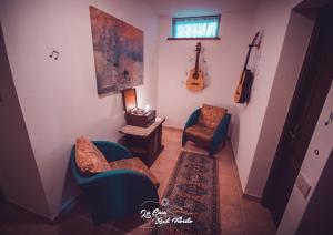 PaganicoLa Casa Sul Fiordo Lago del Turano的客厅配有两把椅子和吉他