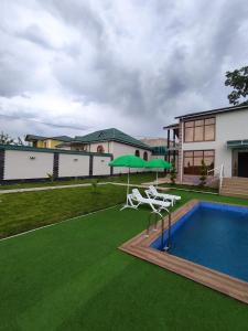 uma casa com uma piscina e um relvado verde em Villa Jumeirah em Gabala