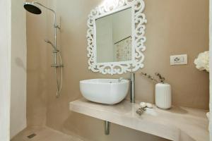 bagno con lavandino e specchio di Chez MaMa' Rooftop - SIT Apartment a Lecce