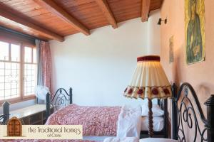 a bedroom with a bed with a lamp and a window at Elounda Collection Villa in Vrouchas