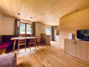een woonkamer met een eettafel en een tv bij Appartements Birkenhof in Lech am Arlberg