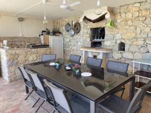 comedor con mesa y pared de piedra en Felicidade, en Loulé