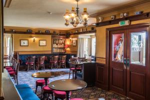 um restaurante com mesas e cadeiras e um bar em The Redgarth em Oldmeldrum