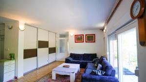 a living room with two blue couches and a table at Neretva River Guesthouse in Konjic